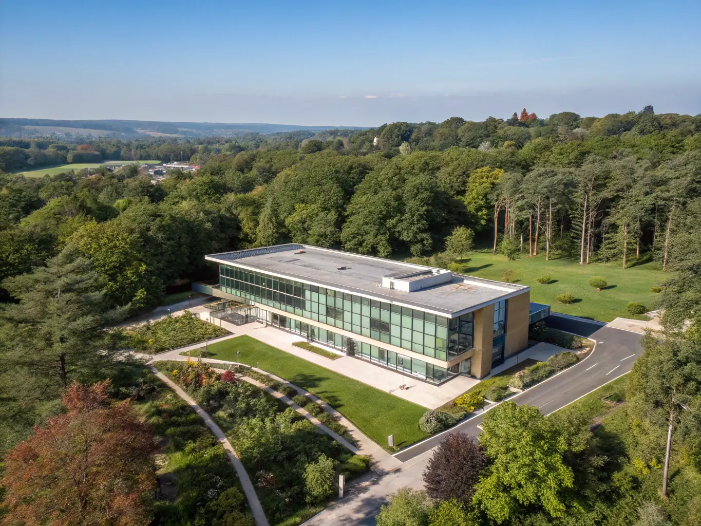 A serene image of a modern hospital exterior in Bangkok, Thailand, with lush tropical plants in the foreground, symbolizing the blend of advanced medical care and natural healing environment.