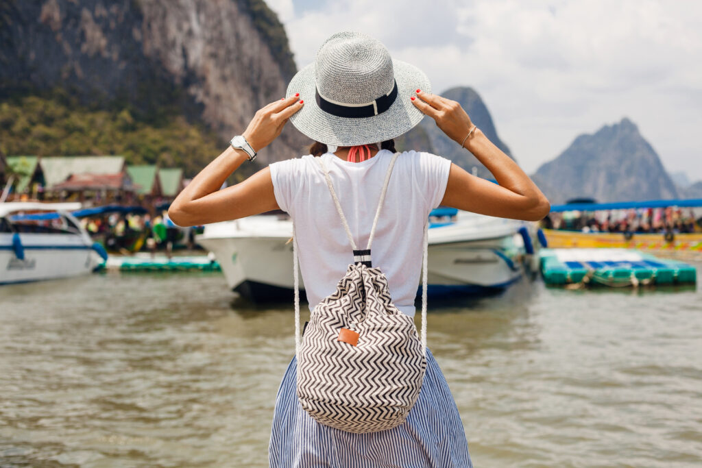 young beautiful woman in summer fashion outfit, casual style, traveling with backpack, hat, sunglasses, vacation in thailand, asia